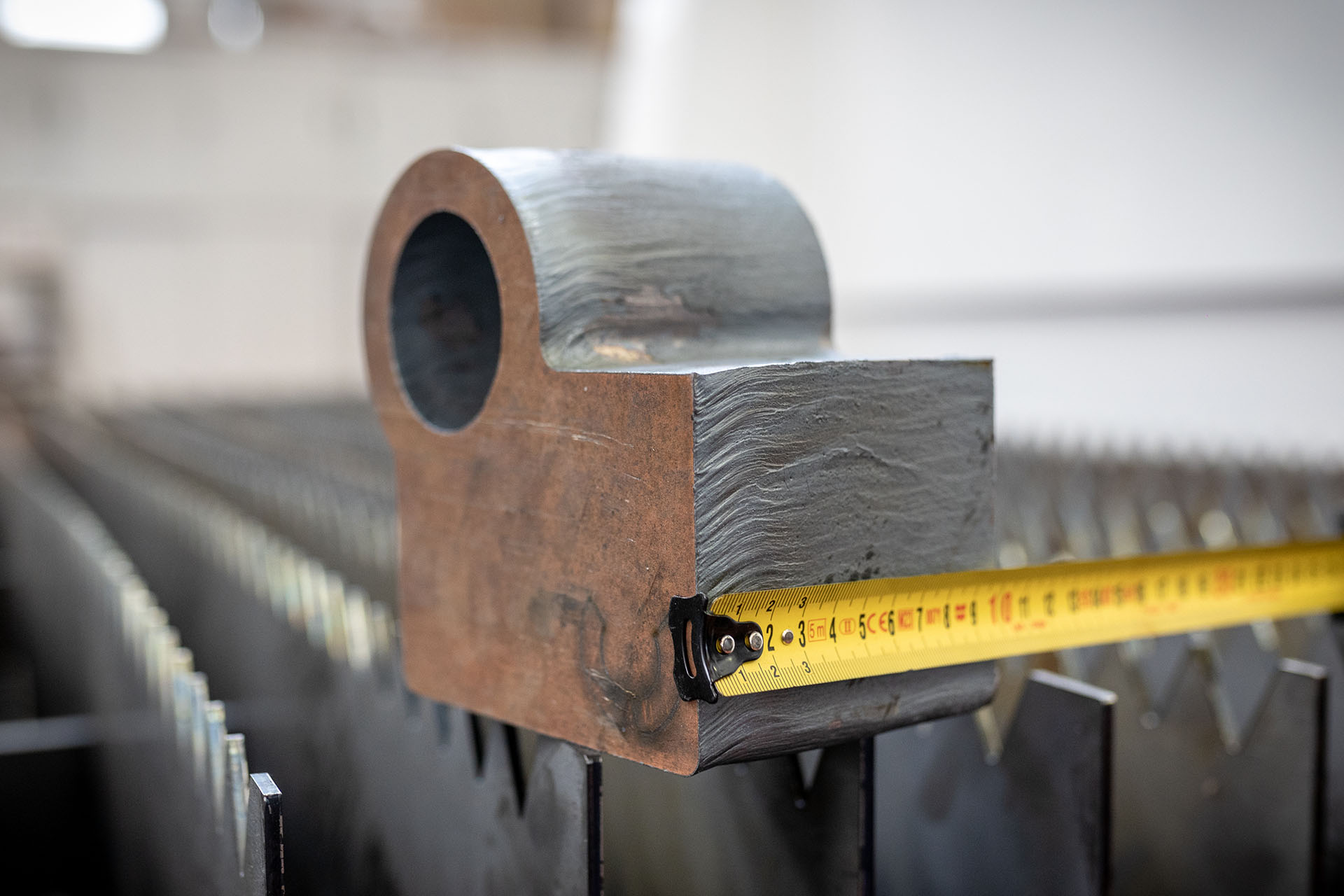 Taglio laser fibra su Hardox da 100 mm, con il metro che mostra lo spessore