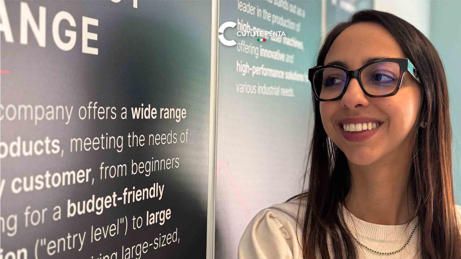 Chiara Tedesco Maida lächelt neben den englischen Präsentationstafeln von Cutlite Penta