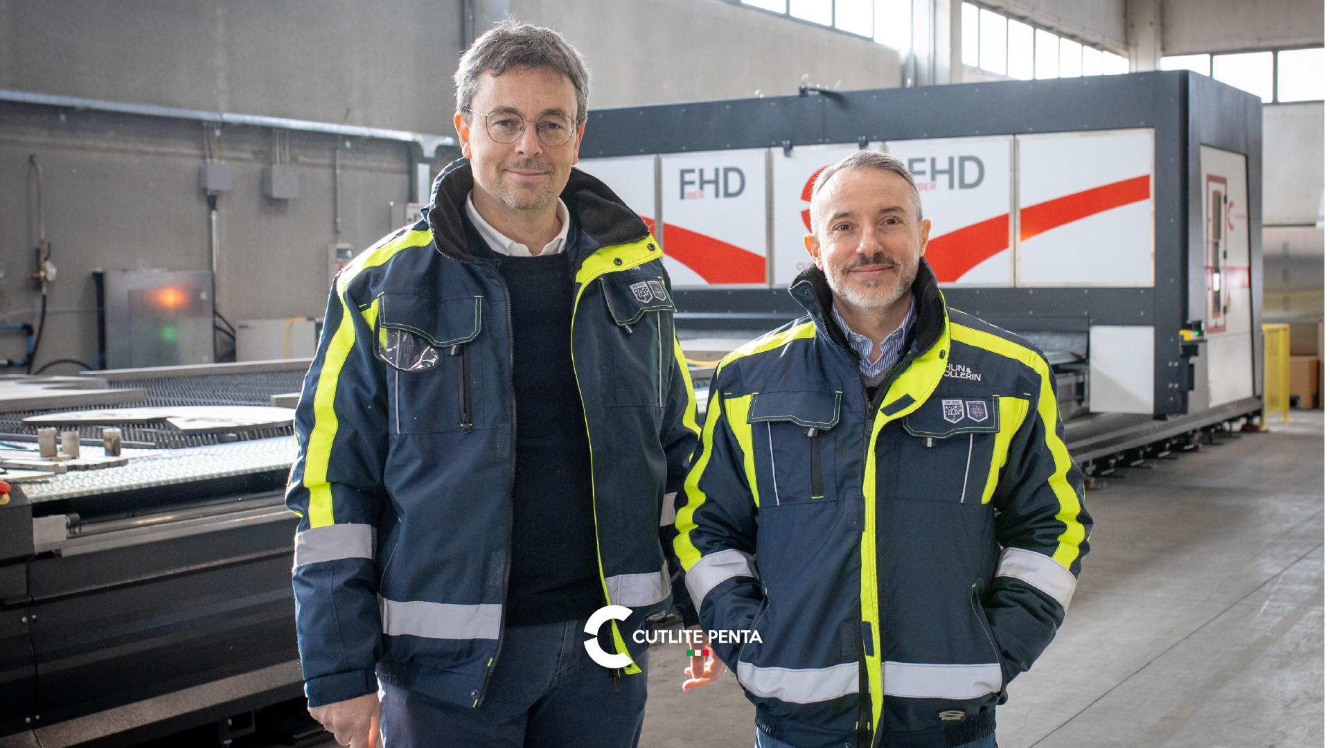 Due responsabili di Chun & Vollerin in giacca da lavoro davanti al sistema di taglio laser fibra FHD Cutlite Penta installato nello stabilimento di Cusago