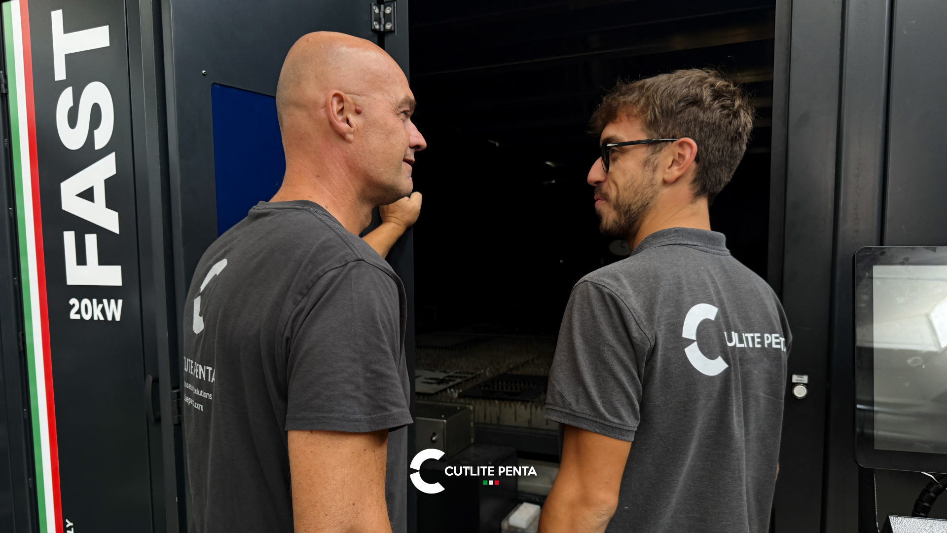 Zwei Cutlite Penta Techniker im Gespräch vor der Lasermaschine FAST mit 20 kW bei geöffneter Kabinentür