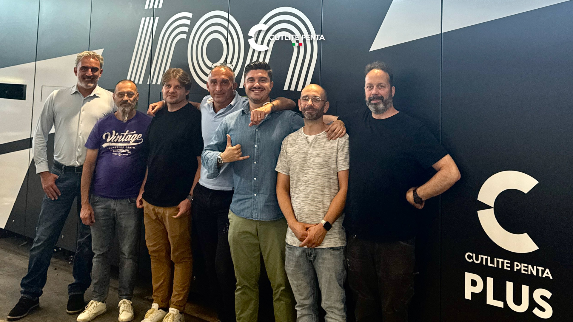 Die Gruppe von Iron SpA und Cutlite Penta vor der Lasermaschine PLUS mit dem iron-Logo