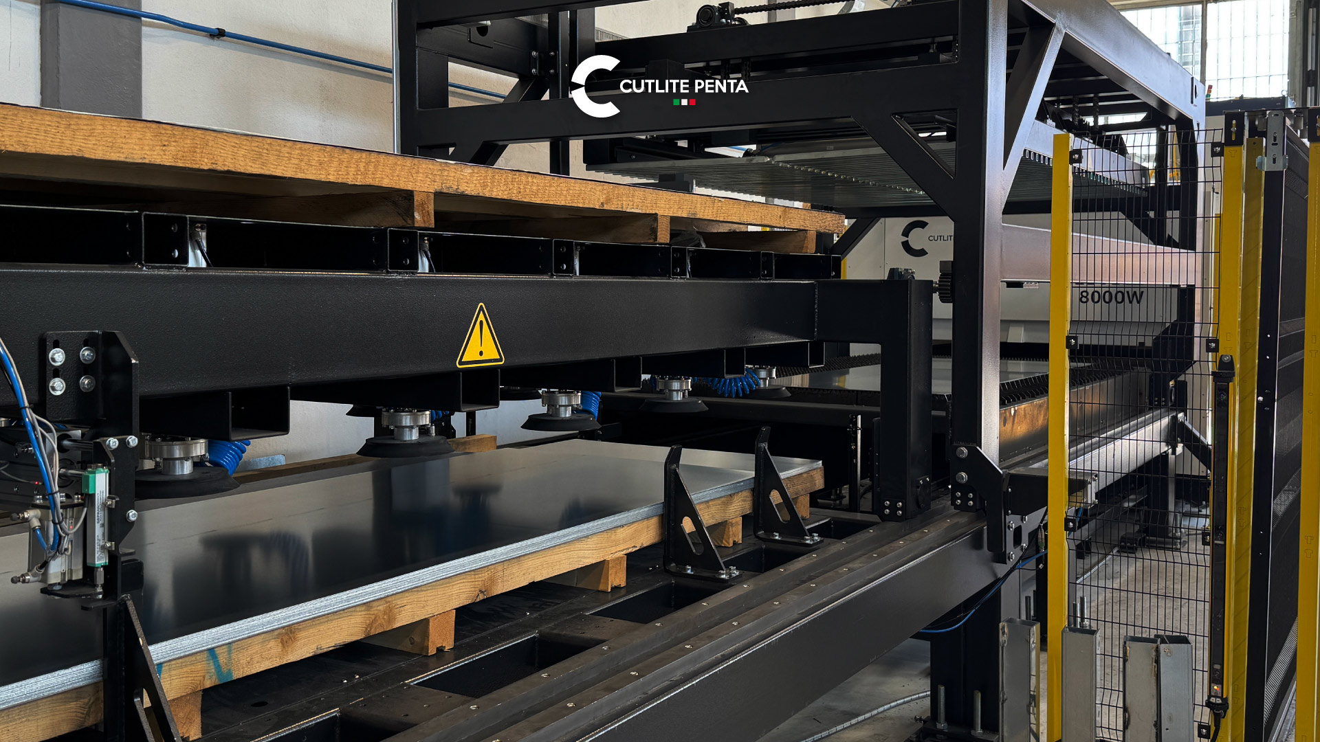 Sistema di carico e scarico automatico con ventose sopra una pila di lamiere, accanto alla macchina laser XME 8000W