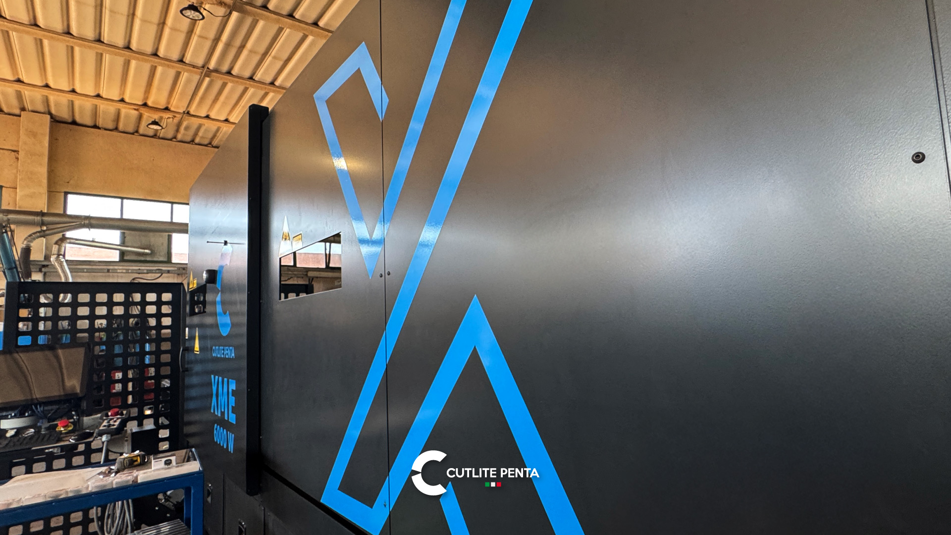 Die Kabine der XME 6000 W von der Seite, mit blauer Grafik und der Halle im Hintergrund