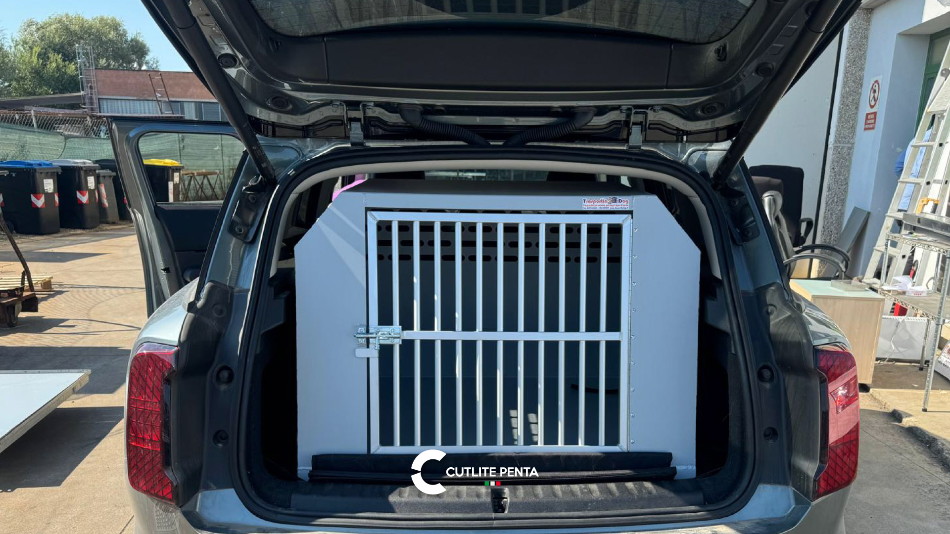 Un trasportino per cani in alluminio Trasportini Dog inserito nel bagagliaio di un'auto