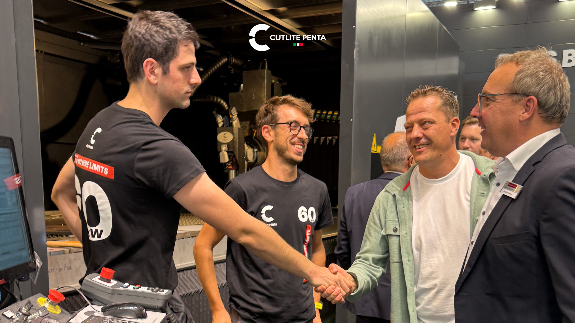 Um aperto de mãos entre técnicos da Cutlite Penta e visitantes diante da máquina laser no estande da Blechexpo 2025