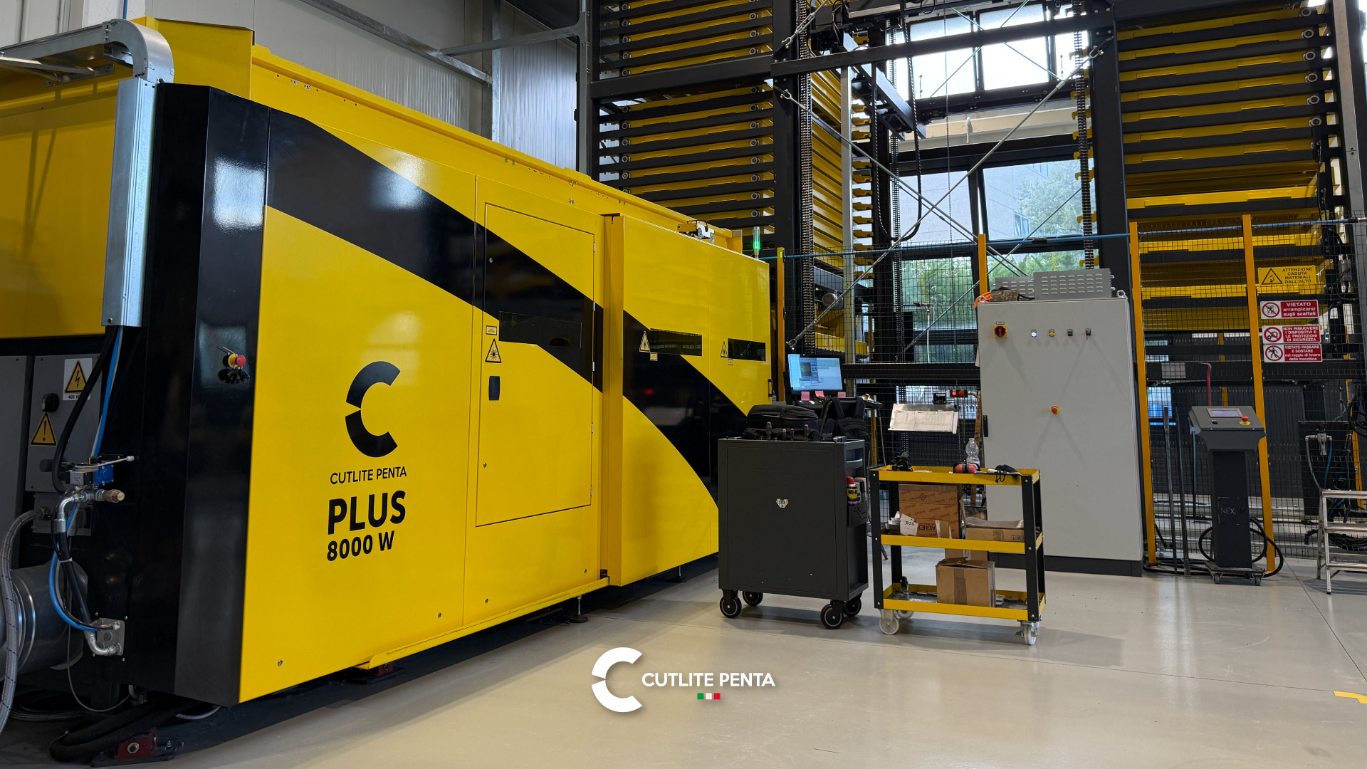 A máquina de corte a laser PLUS 8000 W pintada de amarelo, com o armazém automático de torre dupla atrás