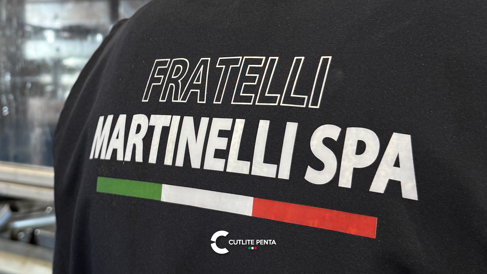 As costas de uma jaqueta de trabalho com a inscrição Fratelli Martinelli SPA e a bandeira italiana