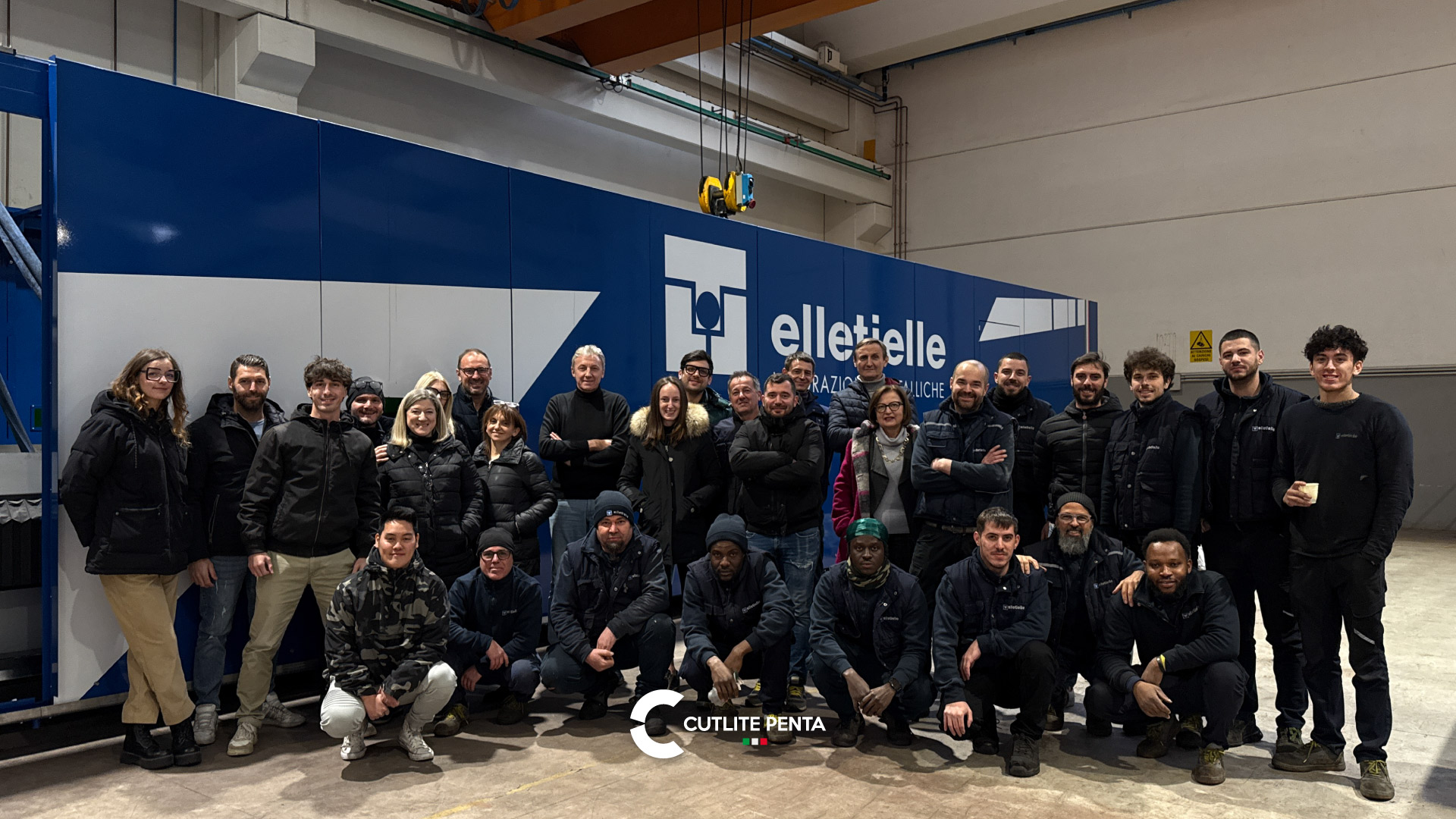 Il team di Elletielle al completo davanti alla macchina PLUS in livrea blu con il logo aziendale
