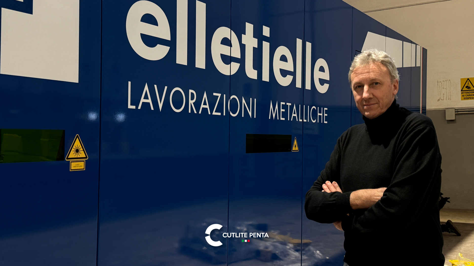 Marco Frasson, presidente di Elletielle, a braccia incrociate davanti alla macchina in livrea blu aziendale