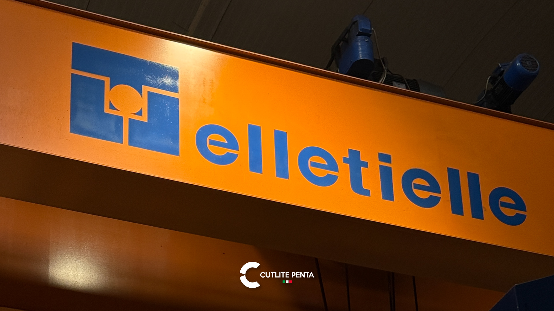 Der orangefarbene Hallenkran mit dem Elletielle-Logo im Werk