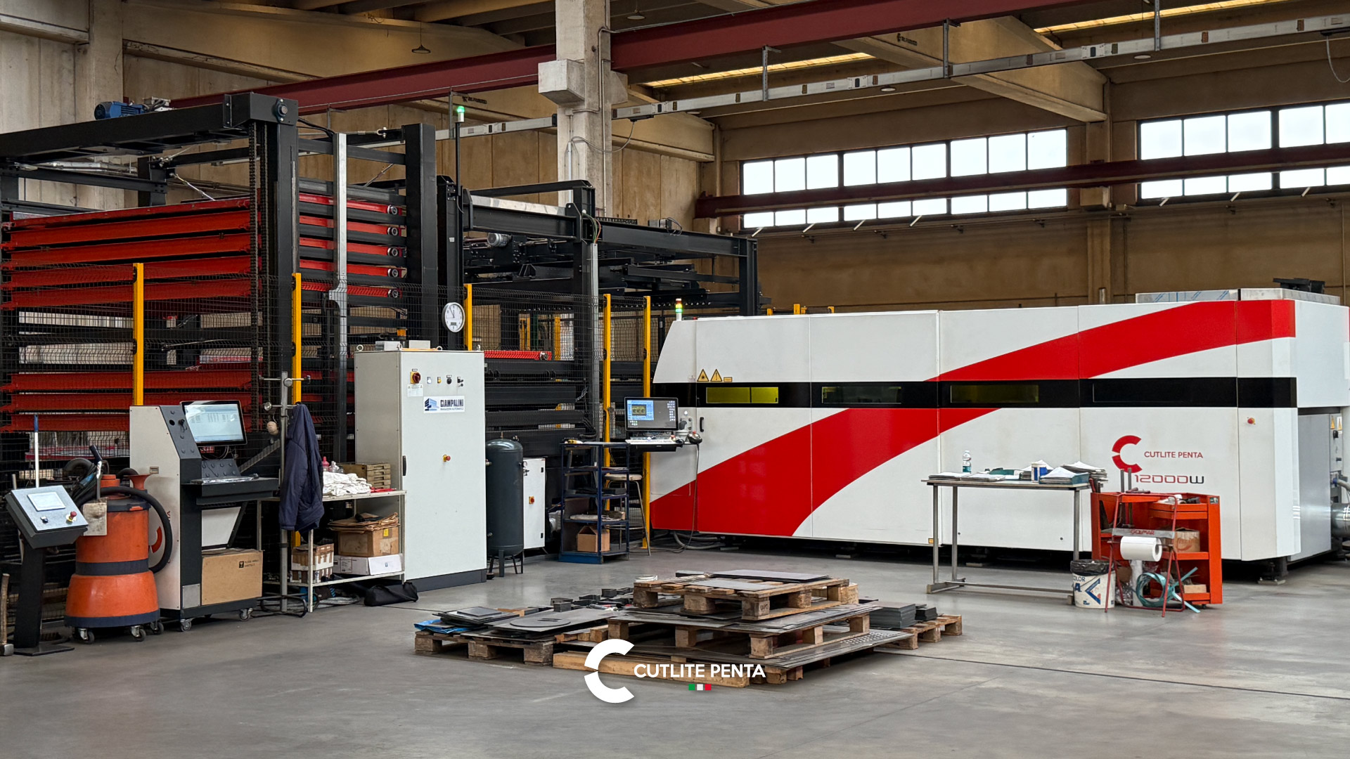 Il reparto taglio di C.M.B Group con la PLUS 12 kW rossa e bianca e il magazzino automatico delle lamiere