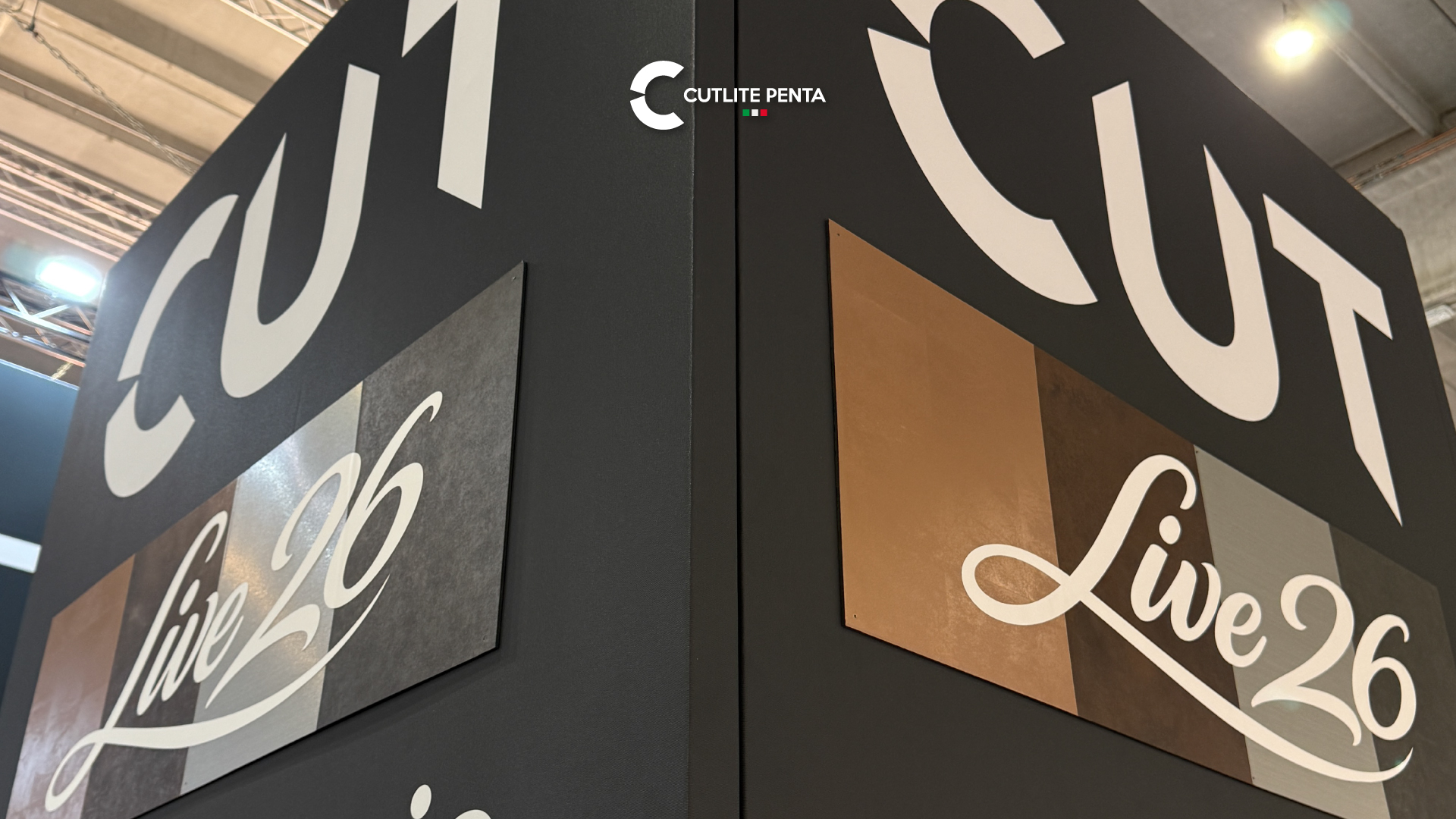 Los paneles CUTLIVE26 en el stand: el logo sobre chapas de distintos materiales, del cobre al acero