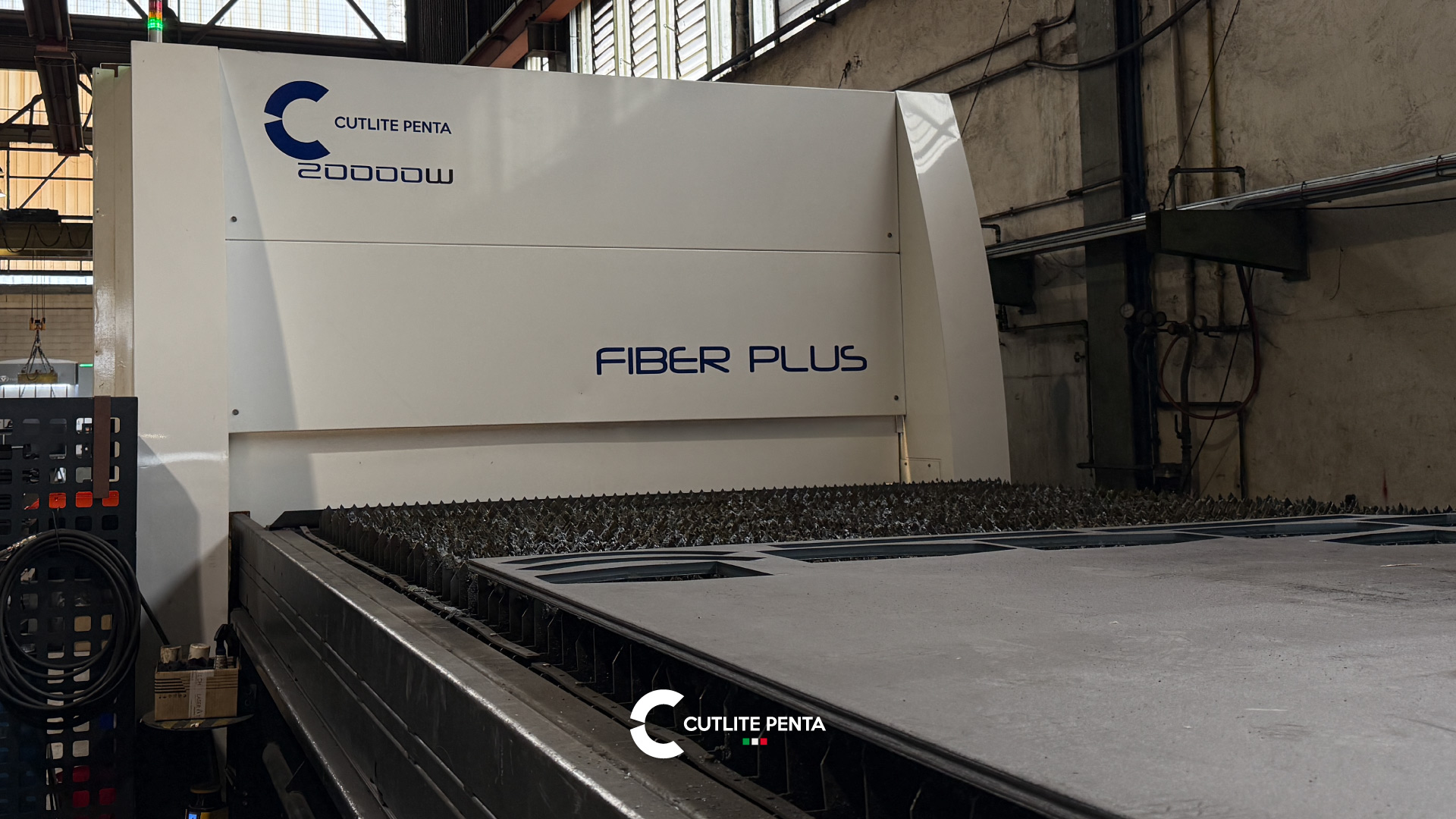 La macchina di taglio laser PLUS da 20 kW di Tecnosider con una lamiera lavorata sul banco