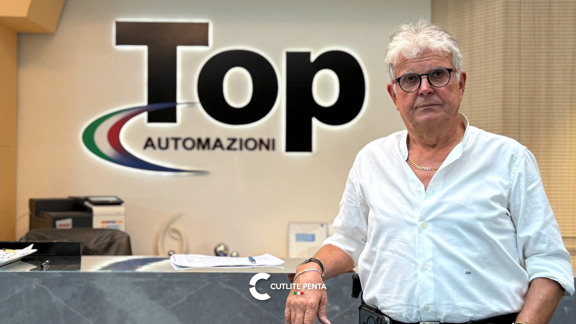 Bruno Bargellini, fundador da Top Automazioni, em frente ao logotipo da empresa