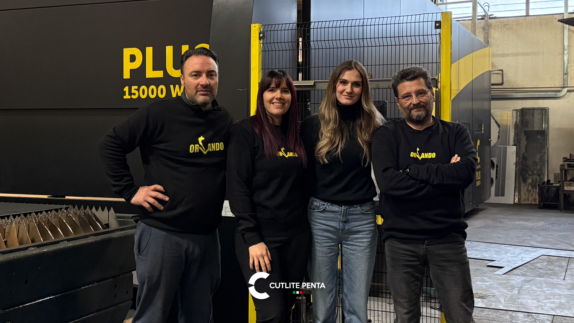 Cuatro miembros del equipo de Orlando Srl delante de la PLUS 15000 W con librea negra y amarilla