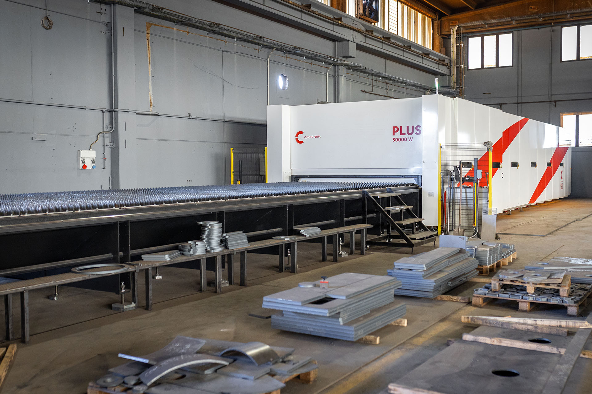 A máquina laser PLUS 30 kW Cutlite Penta instalada na Metalgamma, com as peças cortadas em altas espessuras